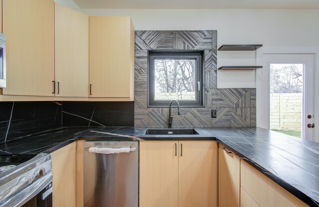 kitchen with stainless steel appliances, sink, light brown cabinets, and a wealth of natural light