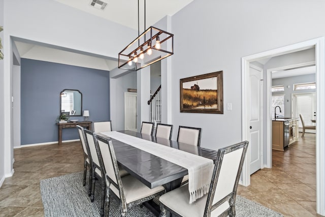 tiled dining room featuring sink and a notable chandelier