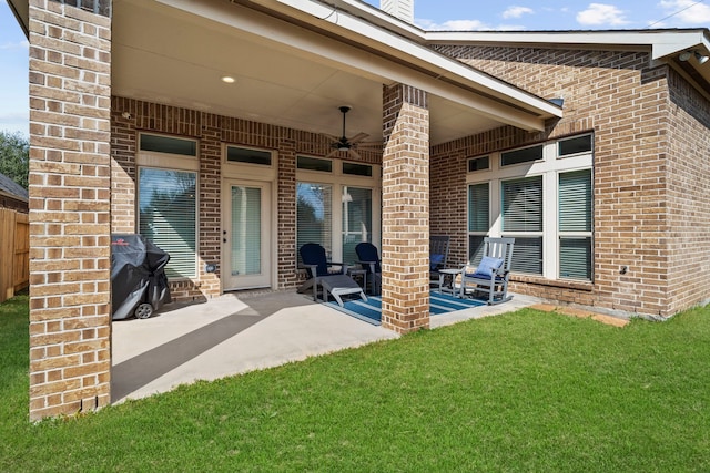 rear view of house featuring ceiling fan, a yard, and a patio