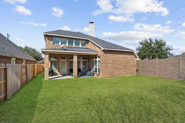 rear view of house with a yard and a patio area