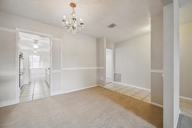 spare room featuring a chandelier, light carpet, and a textured ceiling