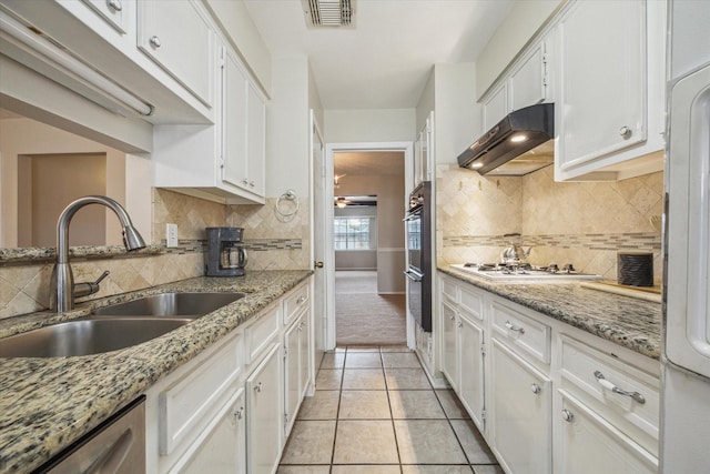 kitchen featuring white cabinetry, sink, light stone countertops, and dishwasher