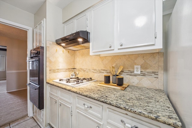 kitchen featuring white gas stovetop, white cabinetry, light stone countertops, and backsplash