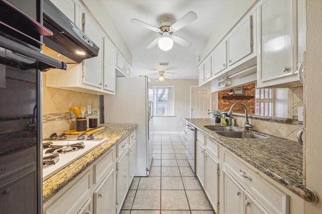 kitchen with sink, white cabinets, light tile patterned floors, light stone countertops, and white gas cooktop