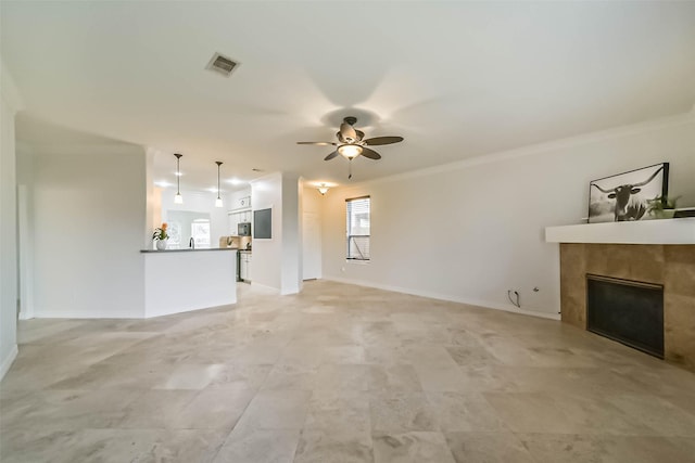 unfurnished living room featuring crown molding, a fireplace, and ceiling fan