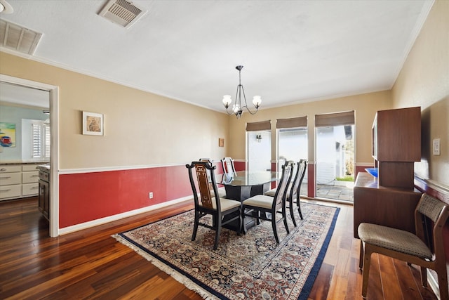 dining space featuring ornamental molding, dark hardwood / wood-style flooring, and a notable chandelier