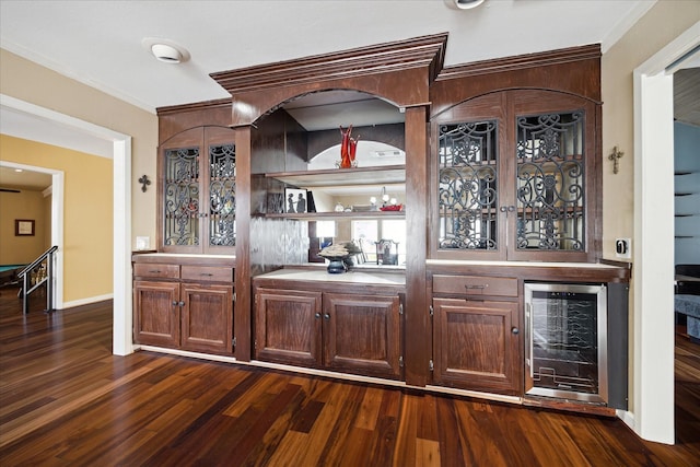 bar with ornamental molding, dark wood-type flooring, and wine cooler