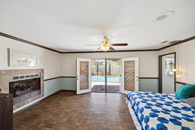 unfurnished bedroom featuring ornamental molding, dark hardwood / wood-style flooring, a tiled fireplace, and access to outside