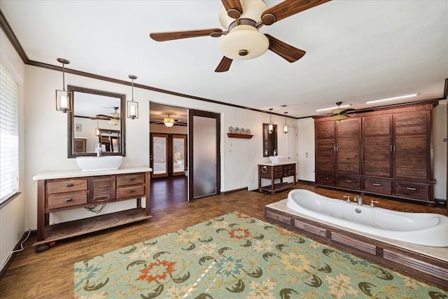 bathroom with french doors, ornamental molding, vanity, hardwood / wood-style flooring, and a washtub