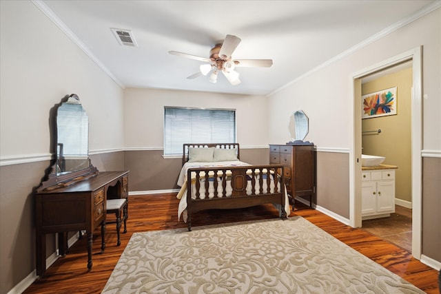 bedroom with crown molding, connected bathroom, ceiling fan, and dark hardwood / wood-style flooring