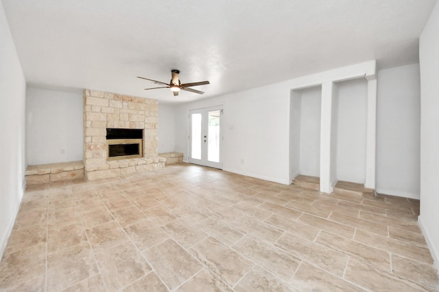 unfurnished living room with a fireplace, french doors, and ceiling fan