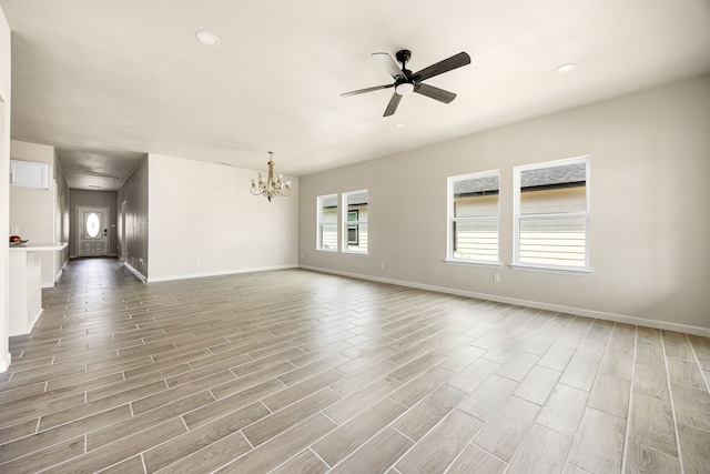 unfurnished room with ceiling fan with notable chandelier and light hardwood / wood-style flooring