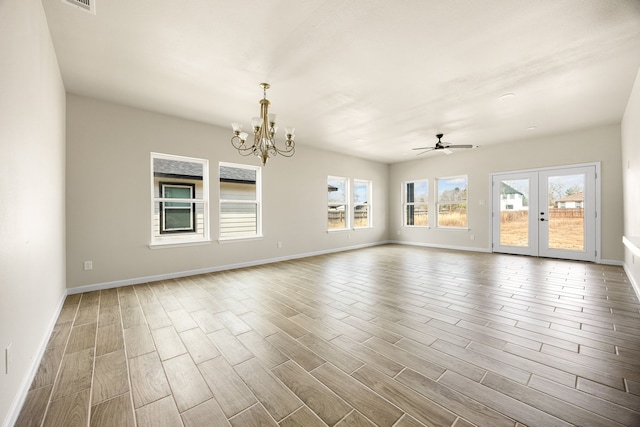 empty room featuring hardwood / wood-style flooring, ceiling fan with notable chandelier, and french doors