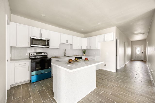 kitchen with a kitchen island, white cabinetry, appliances with stainless steel finishes, and sink