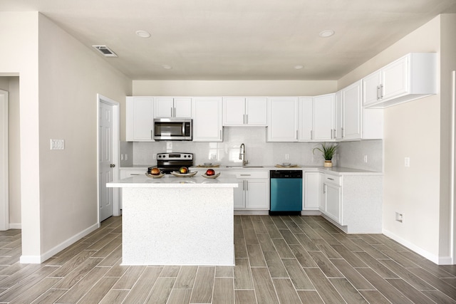 kitchen featuring stainless steel appliances, sink, decorative backsplash, and white cabinets