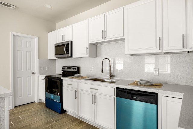 kitchen featuring sink, backsplash, stainless steel appliances, and white cabinets