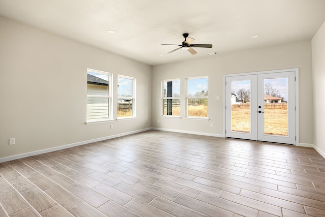 spare room featuring light hardwood / wood-style flooring, ceiling fan, and french doors