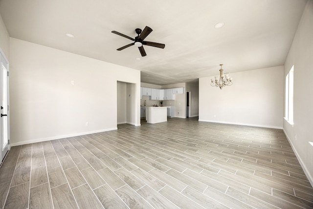 unfurnished living room featuring ceiling fan with notable chandelier and light hardwood / wood-style flooring