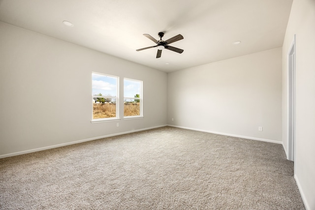 carpeted spare room featuring ceiling fan