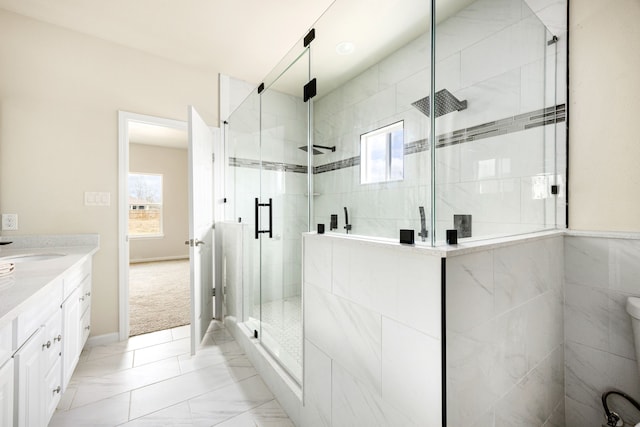 bathroom with walk in shower, vanity, and a wealth of natural light