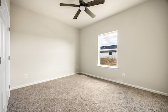 spare room featuring ceiling fan and carpet