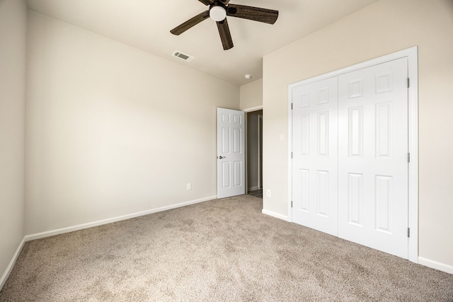 unfurnished bedroom featuring light carpet, a closet, and ceiling fan