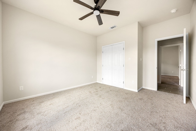 unfurnished bedroom with carpet flooring, ceiling fan, and a closet