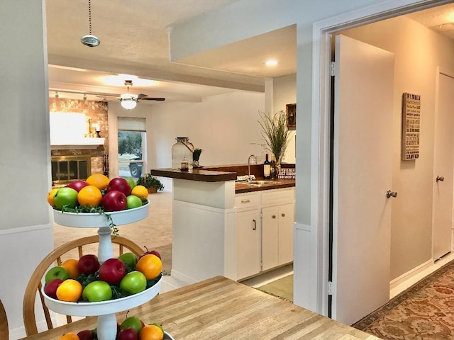 kitchen featuring white cabinetry, ceiling fan, and sink