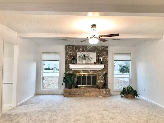 unfurnished living room featuring beamed ceiling, a fireplace, plenty of natural light, and carpet flooring