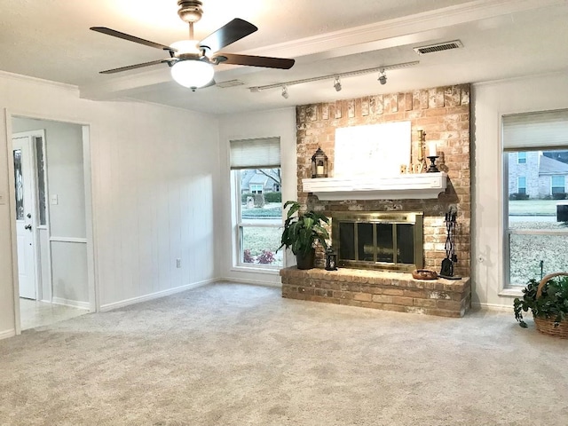 unfurnished living room featuring ceiling fan, carpet flooring, and a brick fireplace