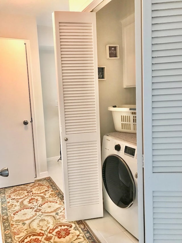 laundry area with washer / clothes dryer and light tile patterned floors