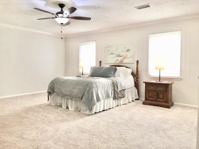 bedroom featuring ceiling fan, ornamental molding, light carpet, and a textured ceiling