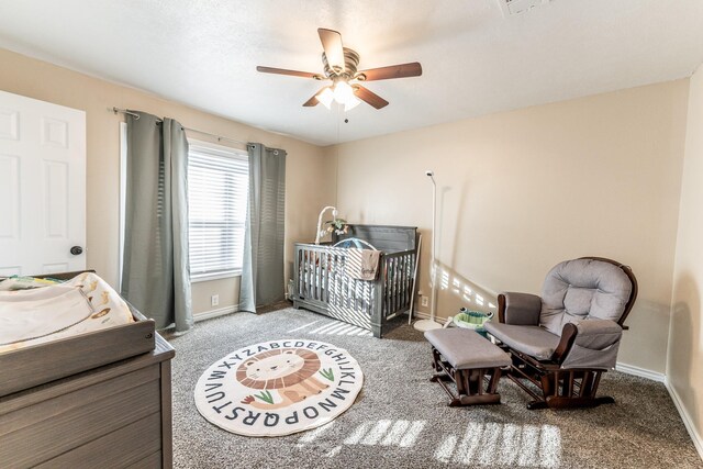 carpeted bedroom with a nursery area and ceiling fan