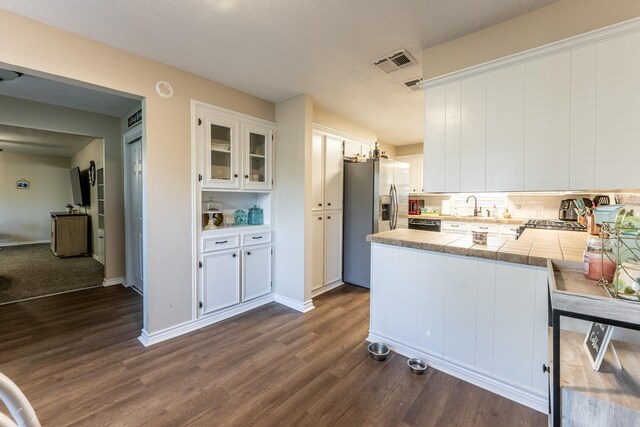 kitchen featuring stainless steel fridge with ice dispenser, dark wood-type flooring, white cabinets, and kitchen peninsula