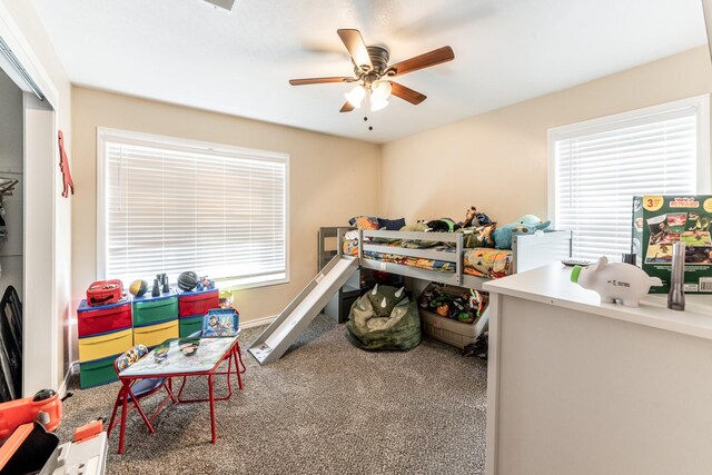 bedroom with ceiling fan, carpet flooring, a closet, and multiple windows