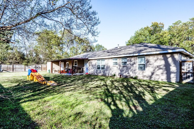 back of property featuring a yard