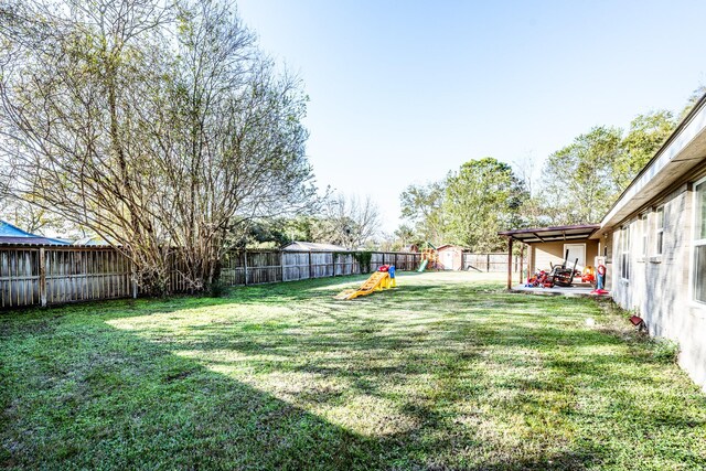 view of yard featuring a patio and a shed