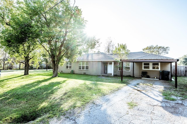 ranch-style house featuring a carport and a front lawn