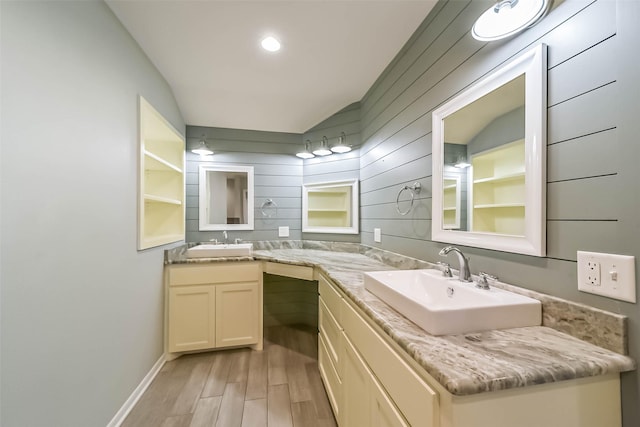 bathroom featuring vanity, vaulted ceiling, and wood-type flooring