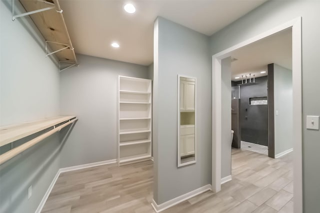 spacious closet with light hardwood / wood-style flooring