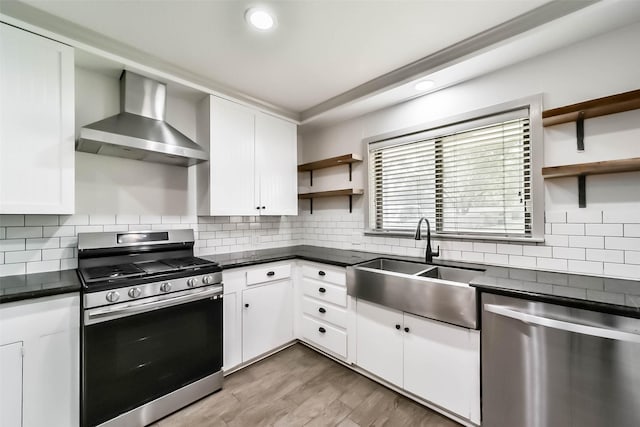 kitchen featuring white cabinetry, sink, wall chimney exhaust hood, and appliances with stainless steel finishes