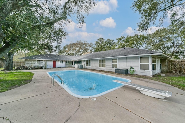 view of pool featuring a patio, a diving board, and central air condition unit