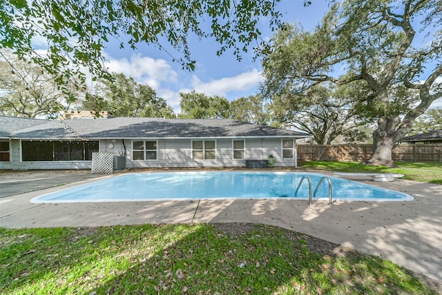 view of swimming pool with central AC, a diving board, and a patio area