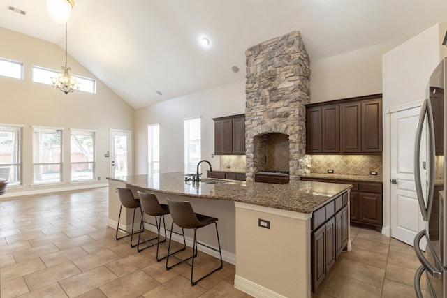 kitchen with dark brown cabinetry and an island with sink