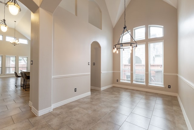 tiled empty room with an inviting chandelier and high vaulted ceiling