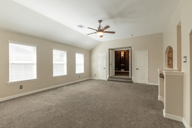 empty room with vaulted ceiling, ceiling fan, and carpet flooring