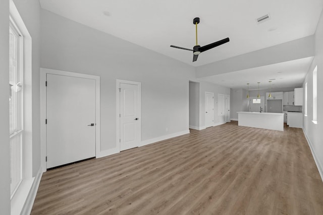 unfurnished living room featuring light hardwood / wood-style flooring and ceiling fan