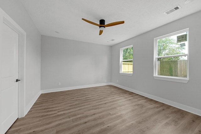 spare room with ceiling fan and light wood-type flooring