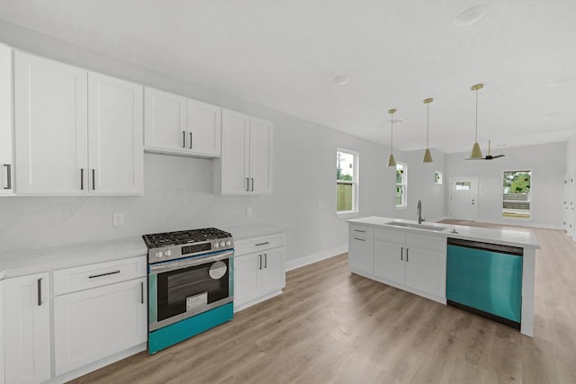 kitchen with pendant lighting, sink, dishwashing machine, white cabinets, and stainless steel range with gas cooktop