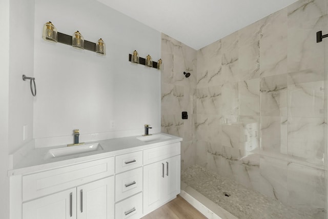 bathroom featuring a tile shower, vanity, and hardwood / wood-style flooring